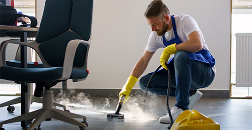 professional cleaning service person using steam cleaner office