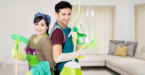 young couple holds cleaning equipment